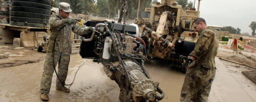 Army Mechanics cleaining a power unit